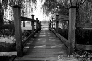 a black and white image of a wooden bridge
