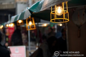 row of lightbulbs above market stalls