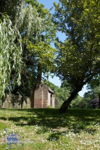 photograph of a small building amongst trees