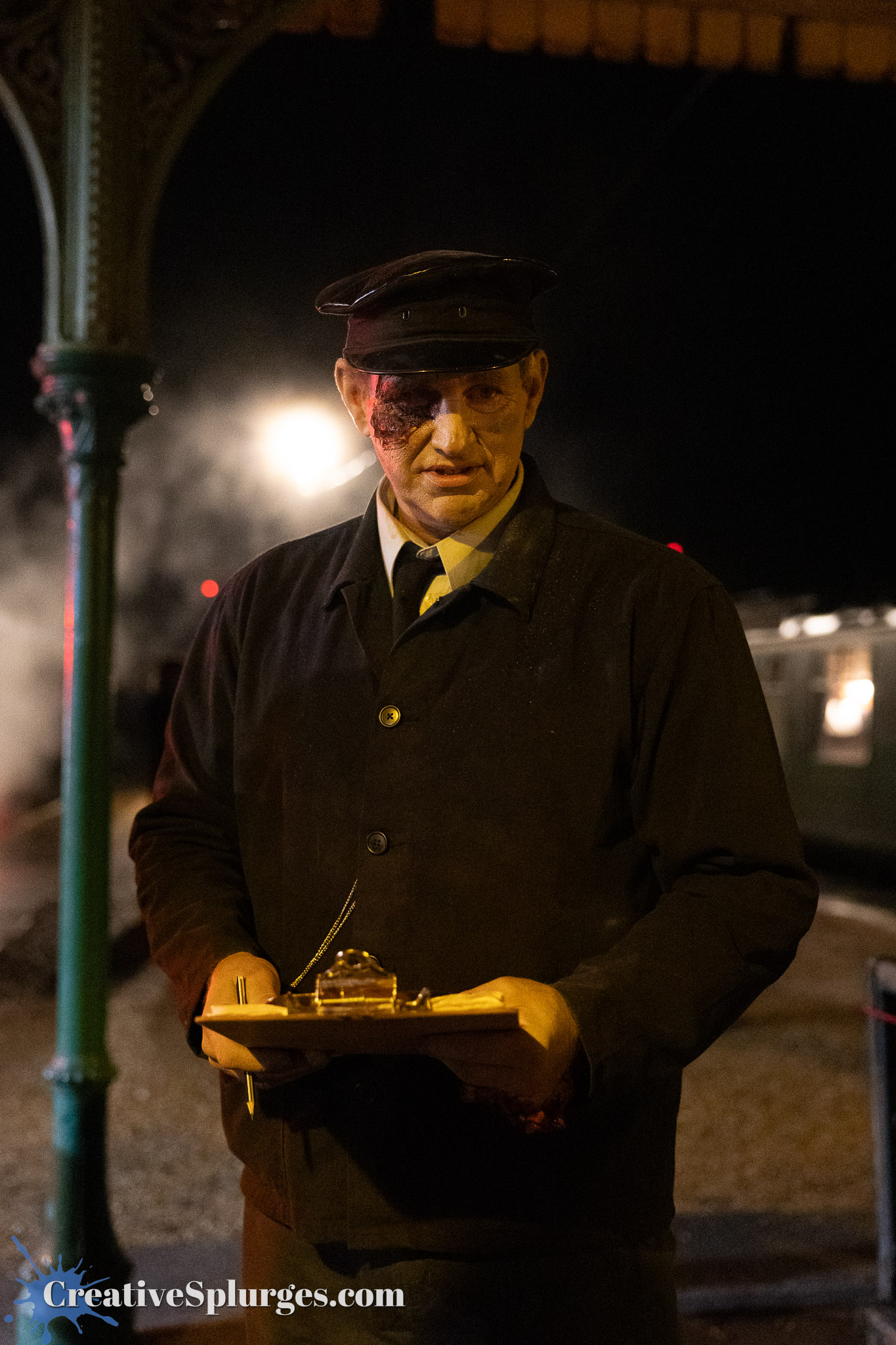 A railroad conductor in uniform stands at a train station at night, holding a clipboard. His face has a noticeable injury, and steam from a nearby train is visible in the background.